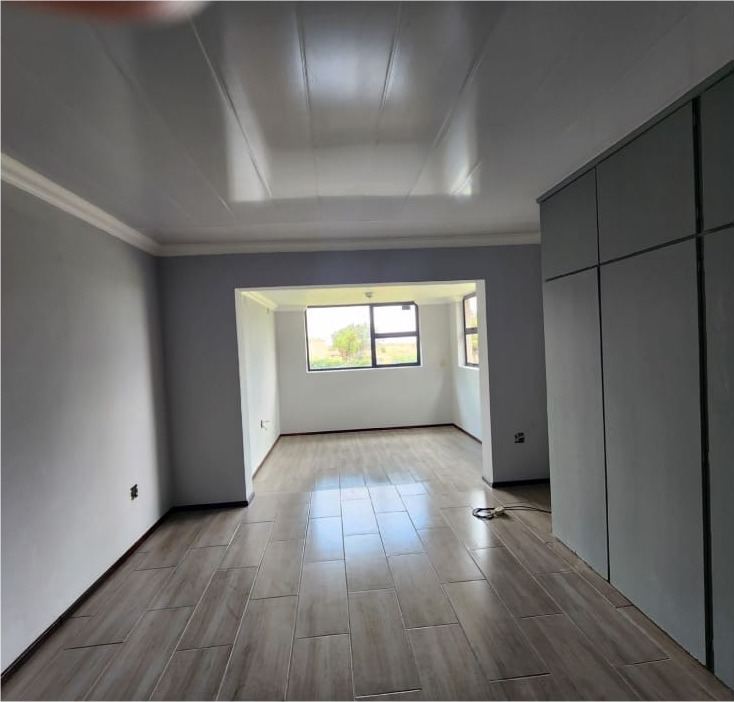 The same bedroom after the renovation, with a new floor and cupboards