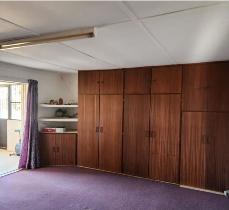 Bedroom before the renovation, with original cupboards and carpet