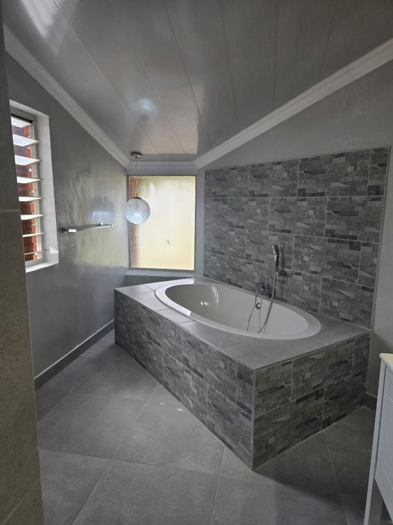 Built in bath clad in stone look tiles