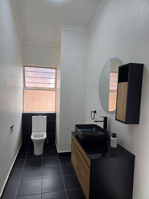 Guest cloakroom in black tiles with a timber vanity