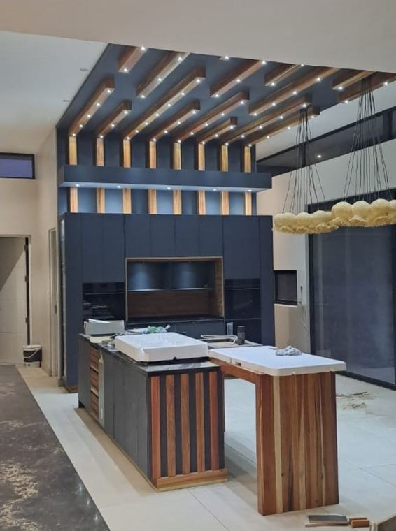 Kitchen under a timber batten ceiling with a solid wood island